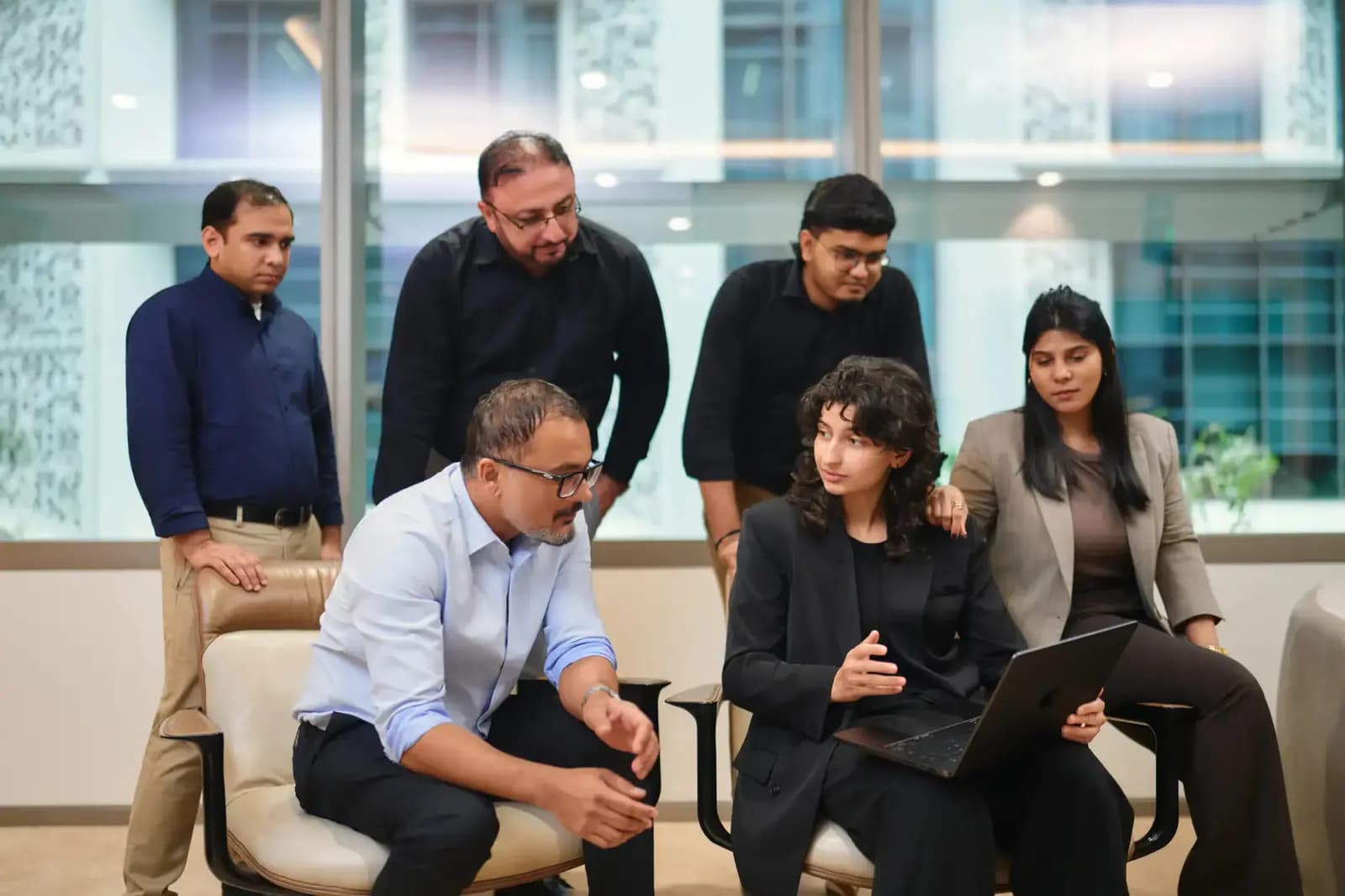 The Permus Software House team gathered around a laptop in their Dubai office